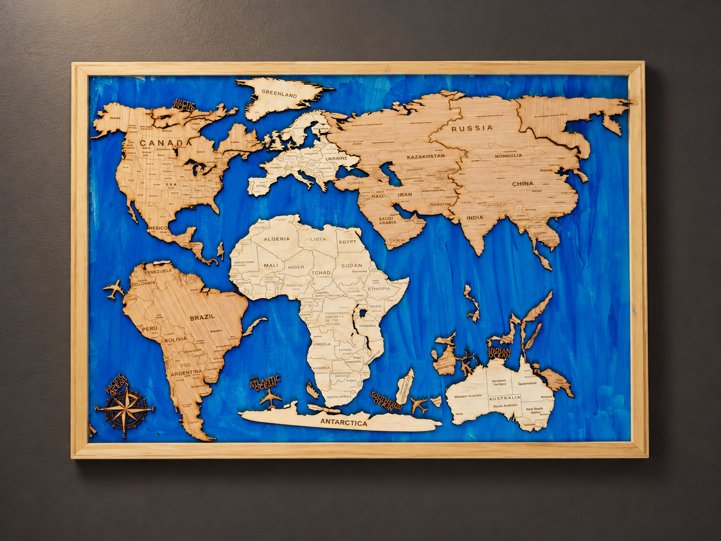 Carte du monde en relief sur fond bleu dans son cadre en bois